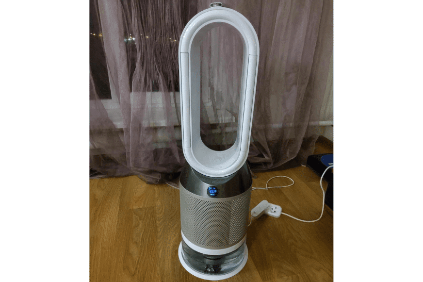 Der Dyson Pure Humidify + Cool PH01 Luftreiniger, Ventilator und Luftbefeuchtung steht auf dem Boden vor einem Fenster